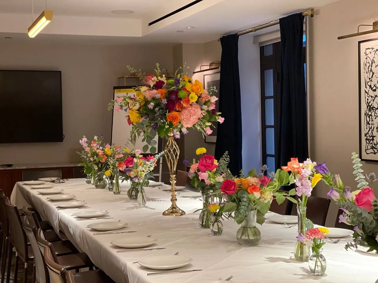 Long table with bright mixed florals at Scarpetta