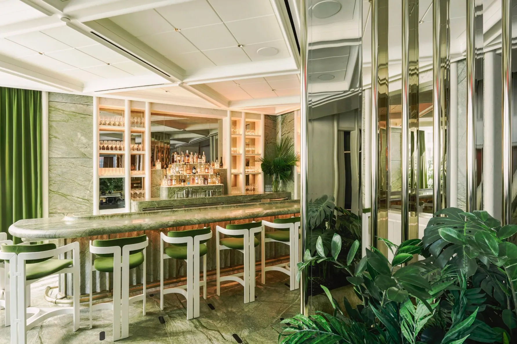Green marble bar with velvet stools at Le Jardinier